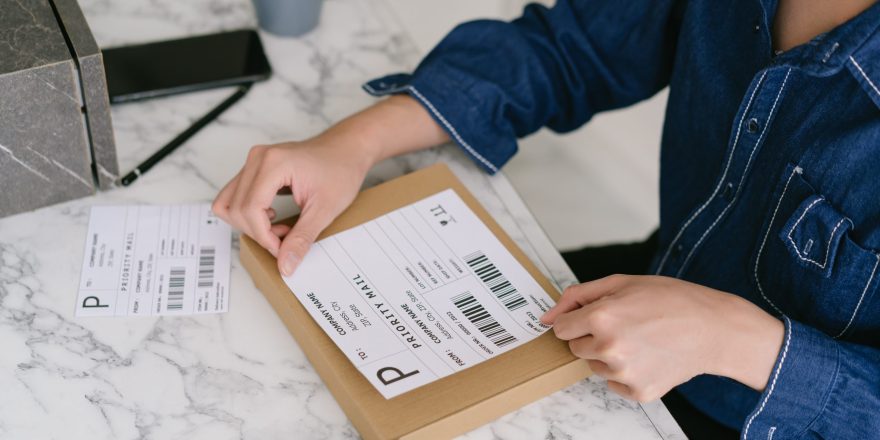 Startup small business SME owner Asian male entrepreneurs packing product shipping order box for dispatching,  labeling delivery package with barcode. Online selling, e-commerce, shipping.Concept.