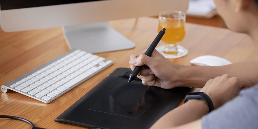 Cropped image of graphic designer working on table in office